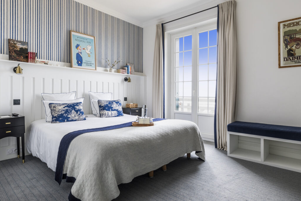 Chambre lumineuse avec plaid de lit en laine recyclée et décoration bleue