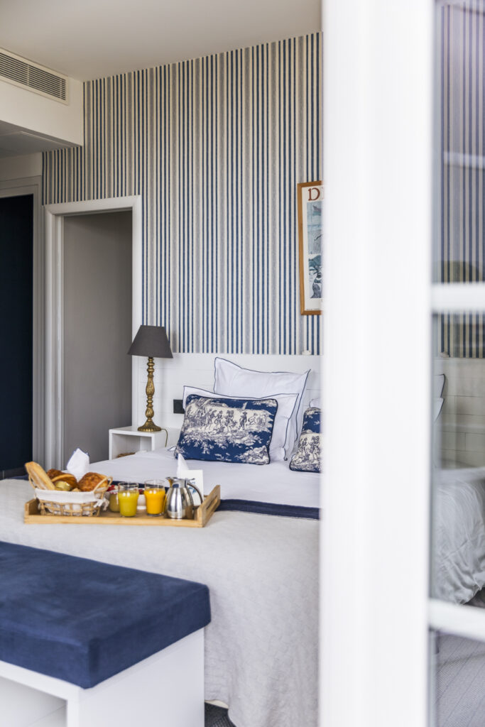 Chambre lumineuse avec plaid de lit en laine recyclée et décoration bleue