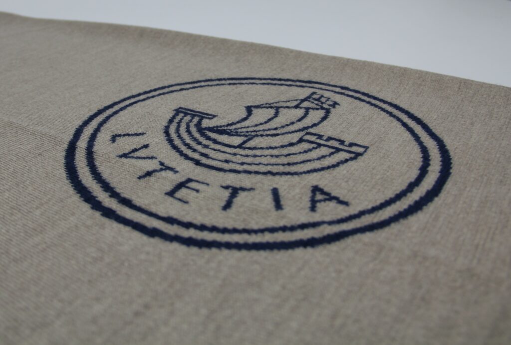 Détail du logo brodé Lutetia sur un textile en maille haut de gamme