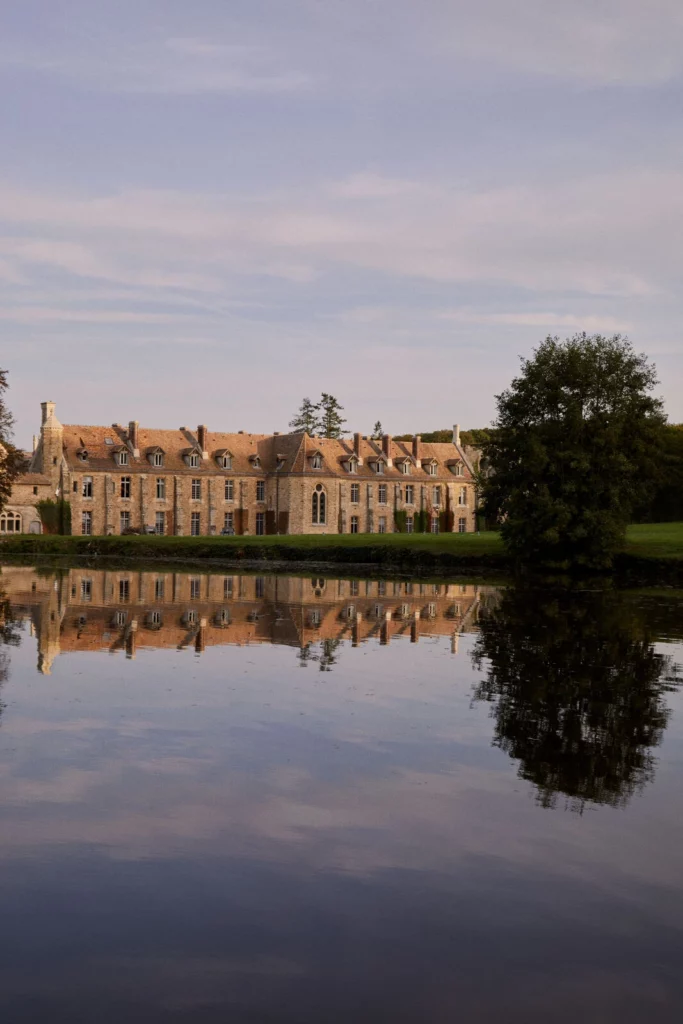 Façade de l’Abbaye des Vaux de Cernay se reflétant dans l’eau, cadre naturel et architectural d’exception