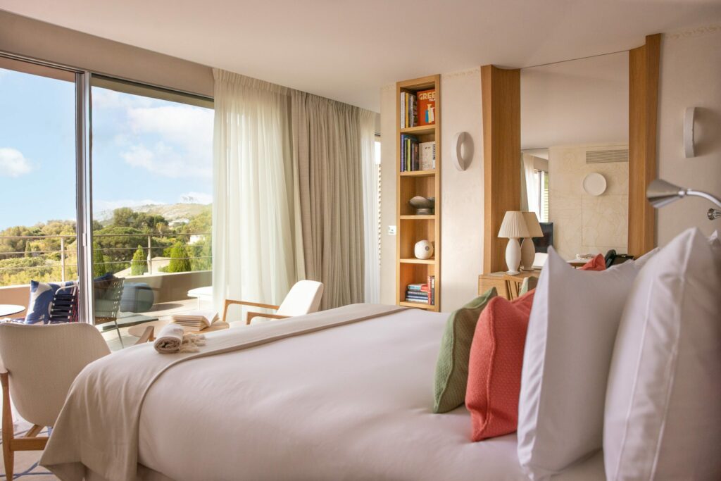 Chambre à La Réserve Ramatuelle avec  plaid sur-mesure lit double et vue ouverte sur terrasse et paysage extérieur