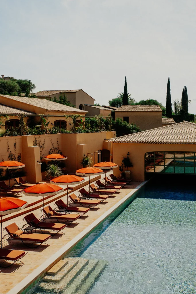Piscine du Mas Candille avec transats et parasols dans un environnement méditerranéen