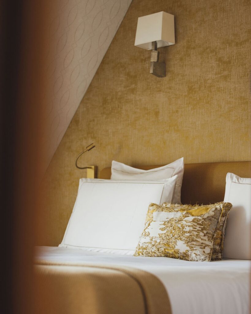 Détail de lit avec coussin décoratif et textile en maille dans une chambre élégante