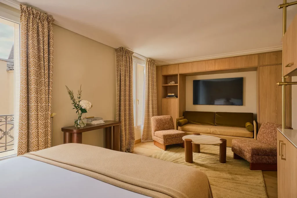 Suite avec espace salon et plaid en maille sur lit, ambiance chaleureuse et contemporaine