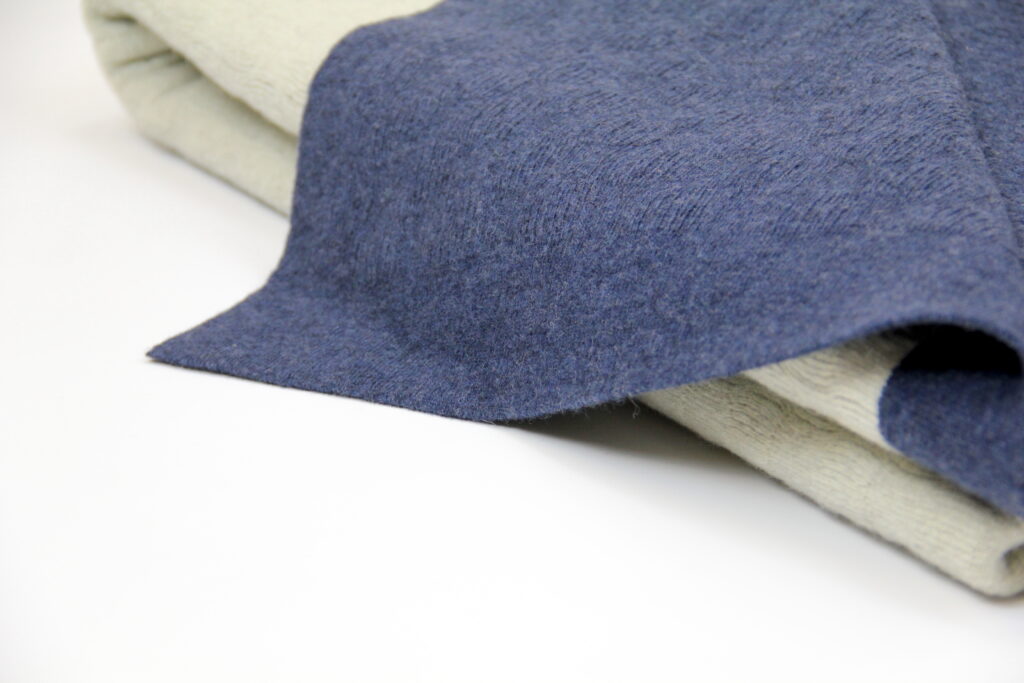 Zoom sur la texture d’un plaid en laine recyclée, détail de la maille