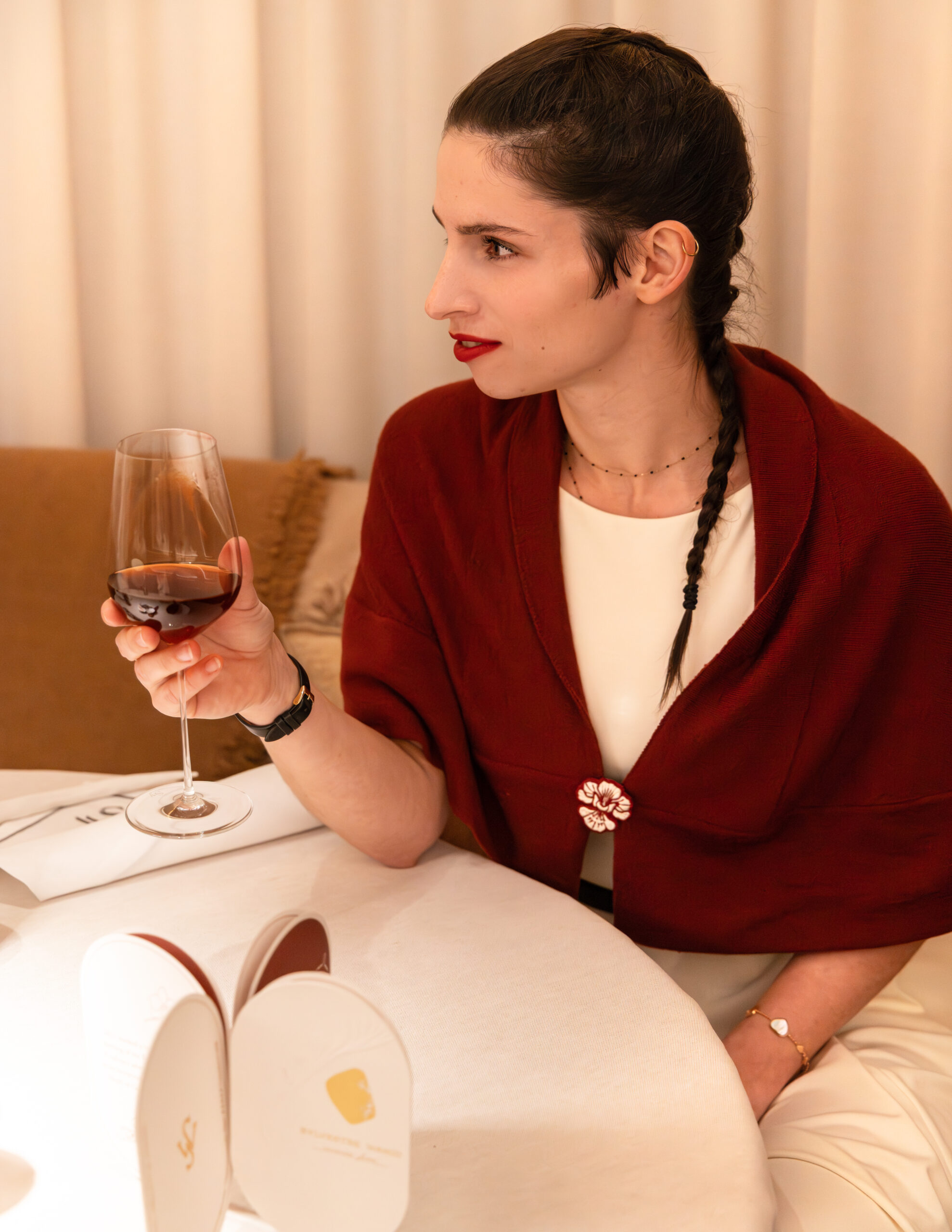 Cliente dégustant un verre de vin dans une ambiance chaleureuse et élégante.
