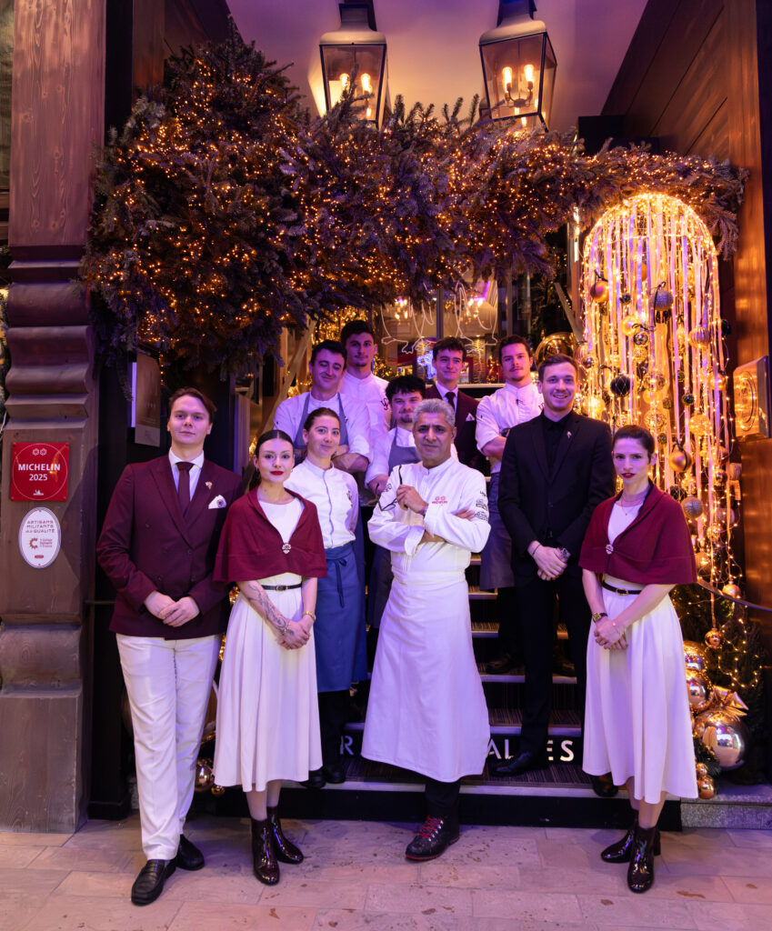 Équipe du restaurant gastronomique Le Sylvestre devant l’entrée décorée pour les fêtes.